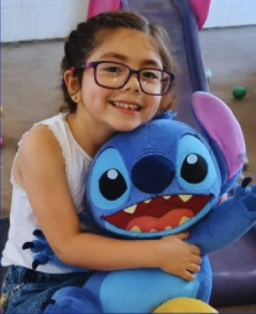 La cumpleañera abrazando a Stitch